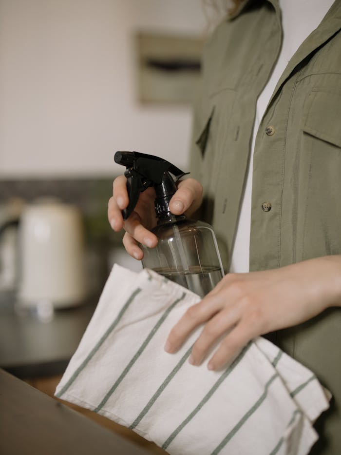 who-we-are Close-up shot of a person cleaning with a spray bottle and cloth. Ideal for cleaning and home care themes.